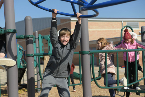 four students play on equipment